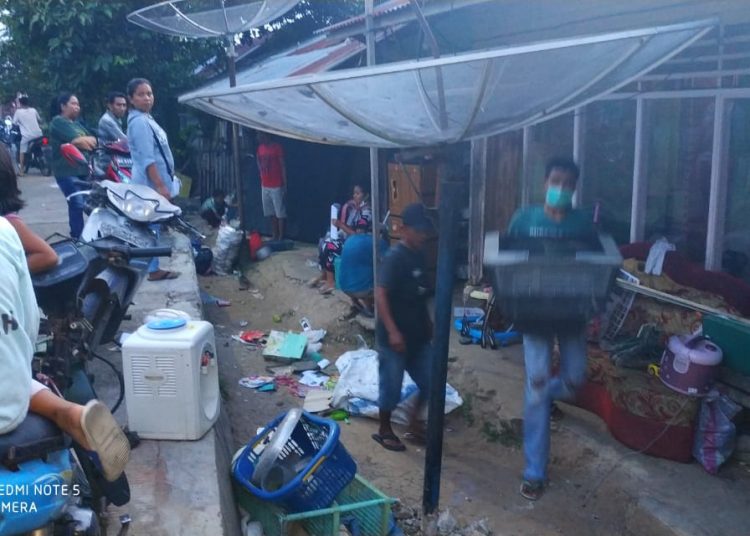Warga membantu Miryanto mengeluarkan barang-barangnya dari rumah kontrakan.